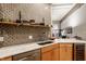 Kitchen featuring marble countertops, wood cabinets, stainless steel appliances, and decorative backsplash at 611 N Park Ave # 104, Indianapolis, IN 46204