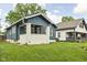 Charming blue home with a white-painted brick porch and well-manicured lawn at 614 N Drexel Ave, Indianapolis, IN 46201