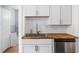 Modern kitchen featuring white cabinets, stainless steel sink, and butcher block countertops at 614 N Drexel Ave, Indianapolis, IN 46201