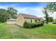 Charming home's backyard with detached garage, lush lawn, and manicured landscaping at 6308 Ratliff Rd, Indianapolis, IN 46113