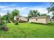 Large backyard with lush lawn, detached garage, and wooden deck with ramp access at 6308 Ratliff Rd, Indianapolis, IN 46113