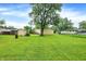 Large backyard with green grass and mature trees offers privacy and space at 6308 Ratliff Rd, Indianapolis, IN 46113