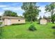 Expansive backyard featuring lush greenery, a detached garage, and storage shed for outdoor living and hobbies at 6308 Ratliff Rd, Indianapolis, IN 46113