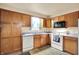 Kitchen featuring wood cabinets and white appliances providing ample storage and functionality at 6308 Ratliff Rd, Indianapolis, IN 46113