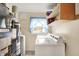 Laundry room with white washer and dryer, blue curtains, and storage shelves at 6308 Ratliff Rd, Indianapolis, IN 46113
