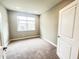 Bedroom with neutral carpeting, a window offering natural light, and a white paneled door at 6350 Stallion Way, Indianapolis, IN 46260
