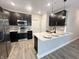 Modern kitchen featuring dark cabinets, stainless steel appliances, and an extended island with seating at 6350 Stallion Way, Indianapolis, IN 46260