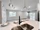 Modern kitchen featuring stainless sink, breakfast bar, and open concept to the living area at 6350 Stallion Way, Indianapolis, IN 46260