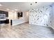 Open-concept living space showcasing modern light fixtures, beautiful floors, and stylish accent wall at 6350 Stallion Way, Indianapolis, IN 46260