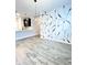 Bright, open living area features modern lighting, stylish accent wall, and wood-look flooring at 6350 Stallion Way, Indianapolis, IN 46260