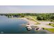 Aerial view of a beach area with docks and a clear blue lake, surrounded by greenery at 6492 Osprey Dr, Nineveh, IN 46164