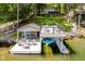 Inviting boat dock with lounge area, bar-height table, and covered boat slip, ideal for lakeside enjoyment at 6492 Osprey Dr, Nineveh, IN 46164