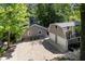 Gravel driveway and gray house with attached garage surrounded by lush trees at 6492 Osprey Dr, Nineveh, IN 46164