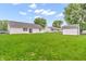Expansive backyard featuring a storage shed, lush lawn, and exterior view of the house at 6853 Kellum Dr, Indianapolis, IN 46221
