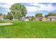 Large grassy backyard features mature trees, a storage shed, and privacy fencing at 6853 Kellum Dr, Indianapolis, IN 46221