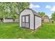 Backyard shed featuring white walls, dark trim, and a dark roof at 6853 Kellum Dr, Indianapolis, IN 46221