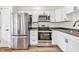 Modern kitchen with stainless steel appliances, sleek hardware, and white cabinets at 6853 Kellum Dr, Indianapolis, IN 46221
