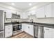 Modern kitchen with white cabinets, stainless steel appliances, and sleek black countertops at 6853 Kellum Dr, Indianapolis, IN 46221