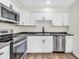 Modern kitchen with white cabinets, stainless steel appliances, and sleek black countertops at 6853 Kellum Dr, Indianapolis, IN 46221