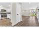 Open living space with wood flooring, white door, kitchen view, and sliding glass doors to the backyard at 6853 Kellum Dr, Indianapolis, IN 46221