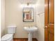 Bathroom with a pedestal sink, gold fixtures, and wood floor at 7082 Hunters Ridge Dr, Plainfield, IN 46168