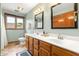 This bathroom features a double sink vanity with modern faucets, a window and neutral wall color at 7082 Hunters Ridge Dr, Plainfield, IN 46168