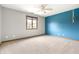 An empty bedroom featuring neutral walls, light carpet, window, ceiling fan and blue accent wall at 7082 Hunters Ridge Dr, Plainfield, IN 46168