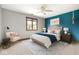 A staged bedroom featuring neutral walls, light carpet, furniture, and a blue accent wall at 7082 Hunters Ridge Dr, Plainfield, IN 46168
