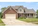 Charming two-story brick home with a covered porch, beautiful lawn, and manicured garden at 7082 Hunters Ridge Dr, Plainfield, IN 46168