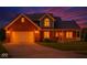 Beautiful two-story brick home with a front porch and manicured lawn at dusk at 7082 Hunters Ridge Dr, Plainfield, IN 46168