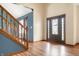Bright, inviting foyer with hardwood floors, staircase, and decorative front door at 7082 Hunters Ridge Dr, Plainfield, IN 46168