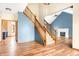 Bright, inviting foyer with wood floors, staircase, and view of the living room at 7082 Hunters Ridge Dr, Plainfield, IN 46168