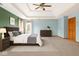 A spacious main bedroom with a tray ceiling, fan, neutral carpet and stylish furnishings at 7082 Hunters Ridge Dr, Plainfield, IN 46168