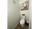 A half bathroom features a toilet, artwork, and wood-look flooring at 7195 W 700 N, Fairland, IN 46126