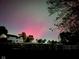 Charming home with a white fence and a vibrant aurora borealis display overhead at 7195 W 700 N, Fairland, IN 46126