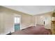 Open living area with classic wallpaper, soft carpet, and doorways into other rooms at 753 Walnut St, Franklin, IN 46131