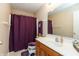 Bathroom with vanity, toilet, shower curtain and matching purple accents at 7818 Fawnwood Dr, Indianapolis, IN 46278
