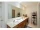 Bright bathroom featuring dual sinks, a large mirror, and wood cabinets offering ample storage space at 7818 Fawnwood Dr, Indianapolis, IN 46278