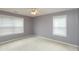 Empty bedroom with carpet flooring, ceiling fan, and two windows providing natural light at 7818 Fawnwood Dr, Indianapolis, IN 46278