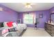 Purple bedroom with pink accents featuring a large bed and dresser with decor at 7818 Fawnwood Dr, Indianapolis, IN 46278