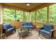 Relaxing screened-in porch with wicker furniture and serene green tree views at 7818 Fawnwood Dr, Indianapolis, IN 46278