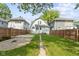 Fenced backyard includes a stone area, small deck, and grassy area at 909 N Parker Ave, Indianapolis, IN 46201