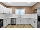 Bright kitchen boasts white cabinets, stainless steel appliances, and wood floors at 909 N Parker Ave, Indianapolis, IN 46201
