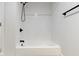 The tub shower features white tile walls with black trim and fixtures at 909 N Parker Ave, Indianapolis, IN 46201