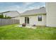 Back patio featuring a fire pit, sliding glass doors, and a well-maintained lawn at 11418 Geist Valley Dr, Indianapolis, IN 46236