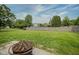 Spacious backyard featuring a fire pit, lush green lawn, and a classic wood fence at 11418 Geist Valley Dr, Indianapolis, IN 46236
