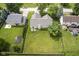 Aerial view of the backyard with a spacious lawn, mature trees, and a charming fence at 11418 Geist Valley Dr, Indianapolis, IN 46236