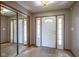 Inviting entryway featuring tile flooring, mirrored closet doors, and a bright white front door at 11418 Geist Valley Dr, Indianapolis, IN 46236