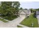 Charming home showcasing a well-manicured lawn, brick accents, and a two-car garage at 11418 Geist Valley Dr, Indianapolis, IN 46236