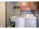 Functional laundry room equipped with washer, dryer, sink, and storage cabinets at 11418 Geist Valley Dr, Indianapolis, IN 46236